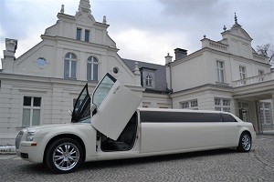 A white Chrysler 300C limousine with Jet Doors outside a stately building in Warsaw, Poland